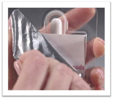 A hand is peeling back the seal of Narcan to open it.